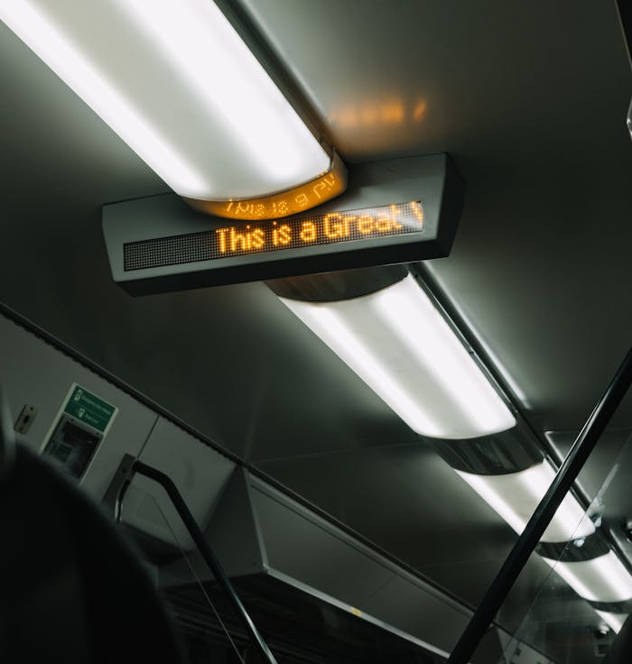 From below of electronic signboard and modern burning lamps located on ceiling of modern subway carriage